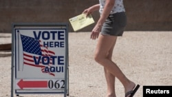 Glasač nosi prijevremeni glasački listić na biračko mjesto u Regionalnom centru Morris K. Udall tokom primarnih izbora u Arizoni, 2. augusta 2022. 