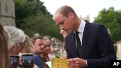 Pangeran William, Pangeran Wales dari Inggris dan Kate, Putri Wales, bertemu dengan anggota masyarakat di jalan-jalan di Kastil Windsor, setelah kematian Ratu Elizabeth II pada hari Kamis, di Windsor, Inggris, Sabtu, 10 September 2022. (Kirsty O'Connor melalui AP)