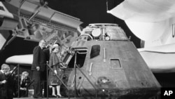La reina Isabel II observa la cápsula del Apolo 14, enviada a la luna en 1971, durante su estancia en la capital estadounidense, el 28 de febrero de 1983. La pieza forma parte en la actualidad del Museo del Aire y del Espacio del Smithsonian en Washington DC.