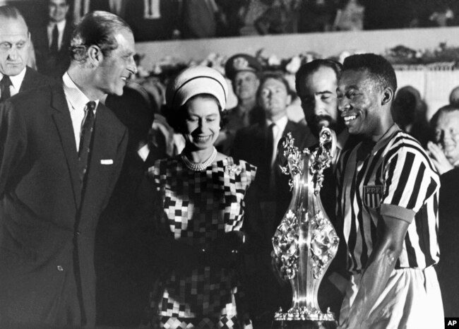 La reina Isabel II y el príncipe Felipe entregan trofeo a la estrella del fútbol Pelé en visita a un estadio en Río de Janeiro, Brasil, el 10 de noviembre de 1968, la monarca estuvo del 5 al 11 de ese mes en visita de Estado.