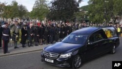 Los miembros del público se alinean en las calles de Ballater, Escocia, mientras el coche fúnebre que lleva el ataúd de la reina Isabel II pasa en su viaje a Edimburgo desde Balmoral en Escocia, el 11 de septiembre de 2022.