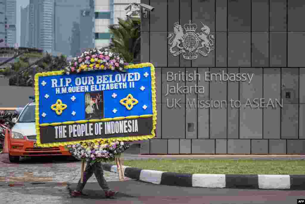 A man delivers a condolence wreath at the British Embassy following the death of Queen Elizabeth II, in Jakarta, Indonesia.