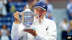 Iga Swiatek of Poland poses for a photo with the championship trophy after defeating Ons Jabeur of Tunisia in the women's singles final of the US Open tennis championships, Sept. 10, 2022, in New York.