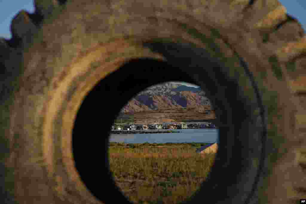 FILE - A truck tire once in the water as part of a marina sits on dry ground as water levels have dropped near the Callville Bay Resort & Marina in the Lake Mead National Recreation Area, Aug. 30, 2022, near Boulder City, Nev. 