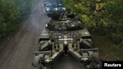Ukrainian service members ride on tanks during a counteroffensive operation in the Kharkiv region of Ukraine, in this handout picture released Sept. 12, 2022, by the Armed Forces of Ukraine.