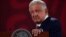 FILE - Mexico's President Andres Manuel Lopez Obrador rests his hand on a lectern during a news conference at the National Palace in Mexico City, Mexico, June 20, 2022.