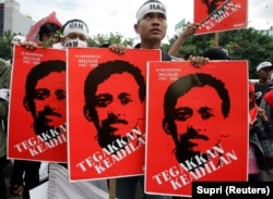 Pengunjuk rasa memegang plakat aktivis HAM Munir Thalib di Jakarta, 20 Desember 2005. (Foto: REUTERS/Supri)