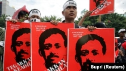 Pengunjuk rasa memegang plakat aktivis HAM Munir Thalib di Jakarta, 20 Desember 2005. (Foto: REUTERS/Supri)