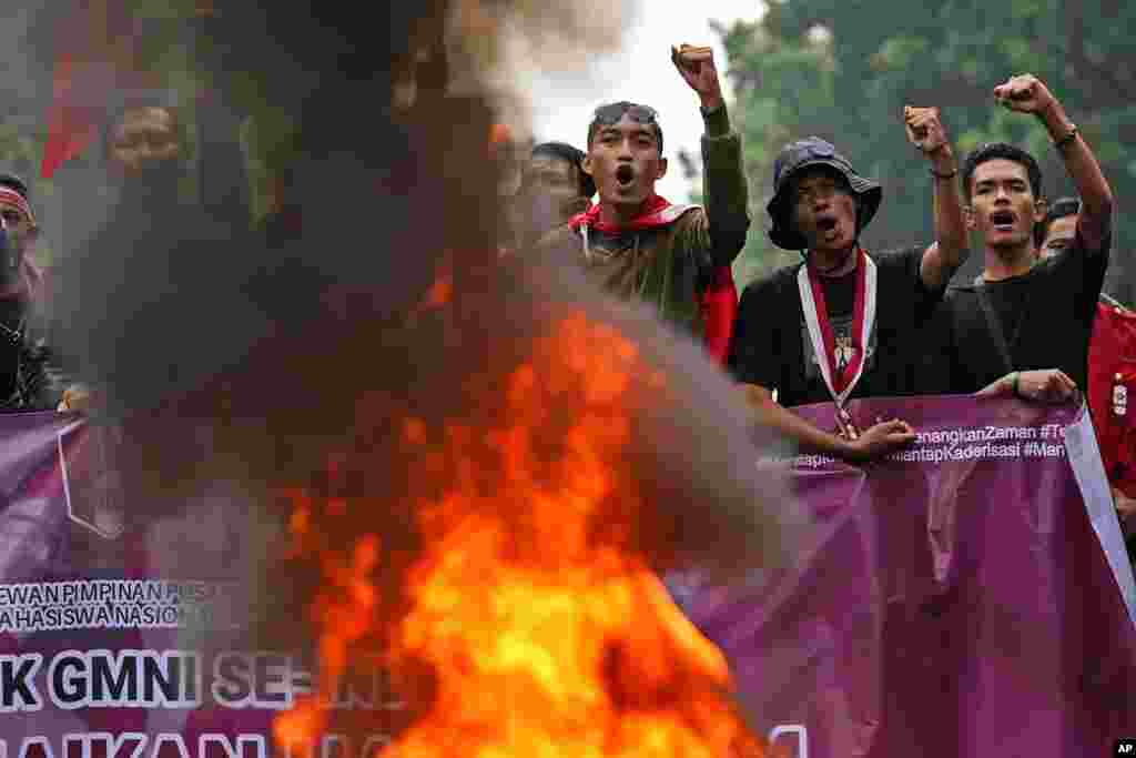 Student activists shout slogans as they burn a tire during a rally against sharp increases in fuel prices, in Jakarta, Indonesia.
