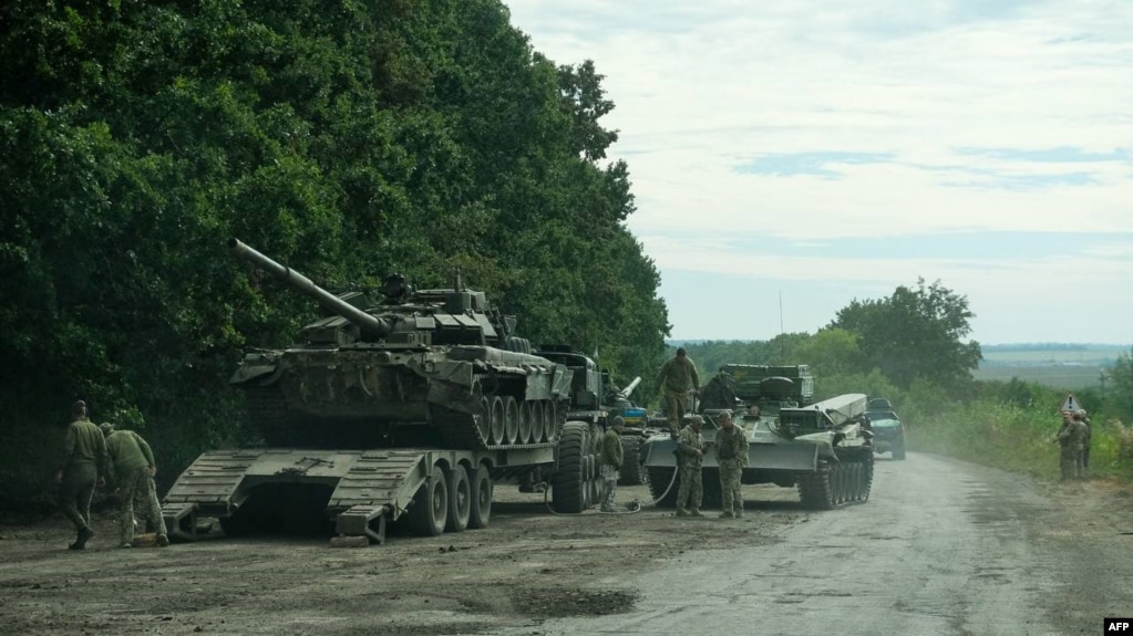 This handout photograph taken Sept. 9, 2022, released Sept. 11, shows Ukrainian soldiers loading an abandoned Russian military vehicle on a trailer during the Ukrainian Army counter-offensive in Kharkiv region. (General Staff of the Ukrainian Armed Forces / AFP)