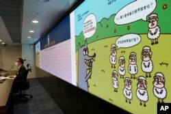 香港警务处国安处官员李桂华（左）在记者会上指控香港言语治疗师总工会5名理事发布“羊村”系列儿童绘本为煽动罪。 （2021年7月22日）