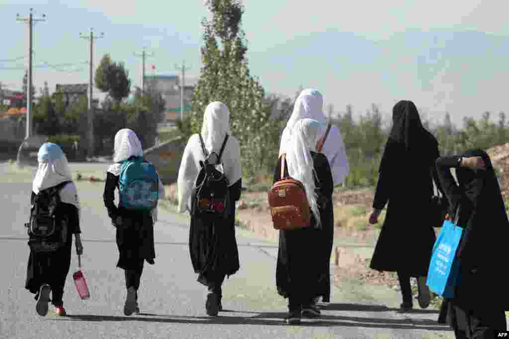 Girls walk to their school along a road in Gardez, Paktia porvince, Afghanistan. Five government secondary schools for girls have resumed classes in eastern Afghanistan after hundreds of students demanded they reopen, provincial officials said on September 8.