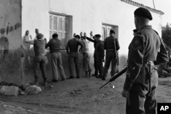 British security troops of the Wiltshire regiment, stationed at Agyrta camp in Kyrenia Mountains of Cyprus, search villagers in Ayios Nicolaos on Dec. 28, 1958, during Christmas patrol against the EOKA, the Greek underground movement.