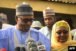 FILE - Nigerian President Muhammadu Buhari, left, with his wife, Aisha Buhari, speaks after voting in his hometown Daura, Nigeria, Feb. 23, 2019.