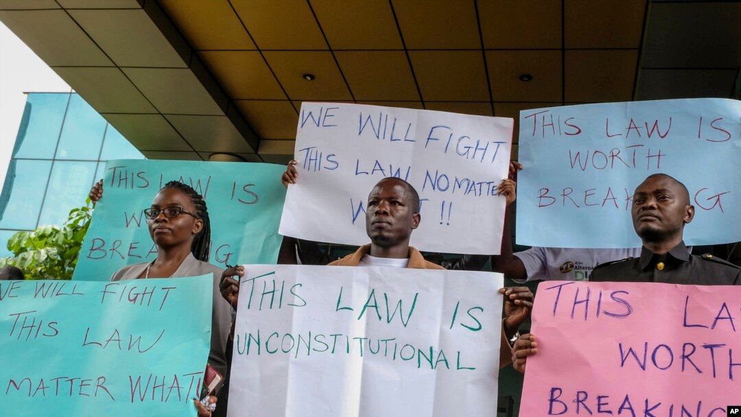 Wanaharataki wa kutetea uhuru wa habari za mitandaoni wakishikilia mabango wakati wakiandamana baada ya kuwasilisha shauri kwenye Mahakama ya katiba mjini Kampala dhidi ya sheria mpya inayoadhibu baadhi ya shughuli kwenye mtandao wa intaneti, Oktoba 17, 2022. Picha ya AP