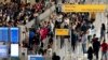 ARCHIVO - La gente espera en una fila de chequeo de seguridad en el Aeropuerto Internacional John F. Kennedy en Nueva York, el martes 28 de junio de 2022.