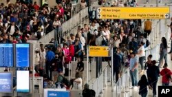 ARCHIVO - La gente espera en una fila de chequeo de seguridad en el Aeropuerto Internacional John F. Kennedy en Nueva York, el martes 28 de junio de 2022.