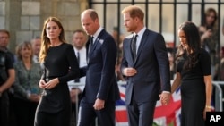 Britain's Prince William, second left, and Kate, Princess of Wales, left, and Britain's Prince Harry, second right, and Meghan, Duchess of Sussex, walk to greet the people outside Windsor Castle, in Windsor, England, Saturday, Sept. 10, 2022.