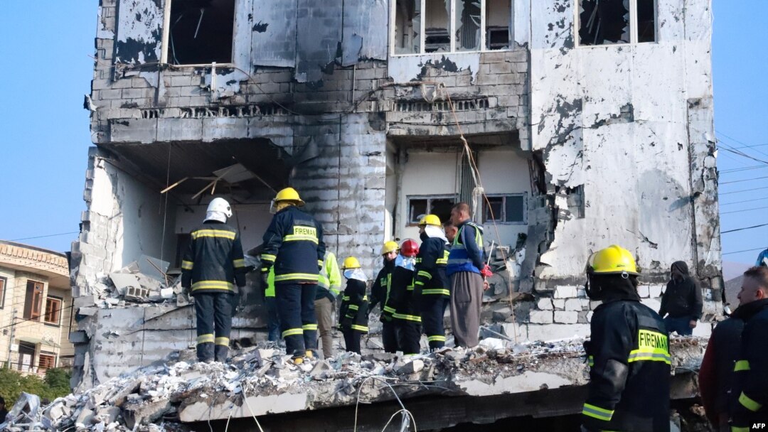People gather as firefighters search for victims and survivors under the rubble of a building which collapsed after gas tank exploded, in the northern Iraqi city of Suleimaniyah, on Nov. 18, 2022.