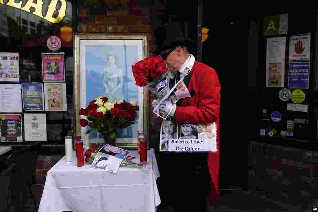 Gregg Donovan, the former ambassador of Beverly Hills, places a bouquet of flowers and photos at a memorial at Ye Olde King's Head British restaurant to honor Queen Elizabeth II in Santa Monica, Calif., Sept. 8, 2022.