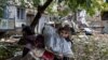 A woman carries her belogings out of a residential building destroyed by a strike in Mykolaiv, Ukraine, amid Russia's invasion of Ukraine, Sept. 11, 2022. 