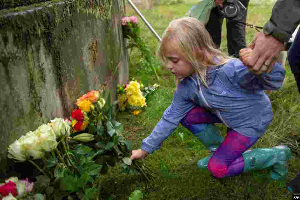 A child lays flowers at the gardens of the Palace of Holyroodhouse in Edinburgh in Scotland, on Sept. 8, 2022, following the announcement of the death of Britain's Queen Elizabeth II. 