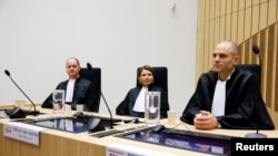 Public prosecutors Ward Ferdinandusse, Manon Ridderbeks and Thijs Berger sit in the courtroom as the Dutch court announces its ruling in the MH17 trial of three Russians and a Ukrainian in the Schiphol Judicial Complex, Badhoevedorp, Netherlands, Nov. 17, 2022.