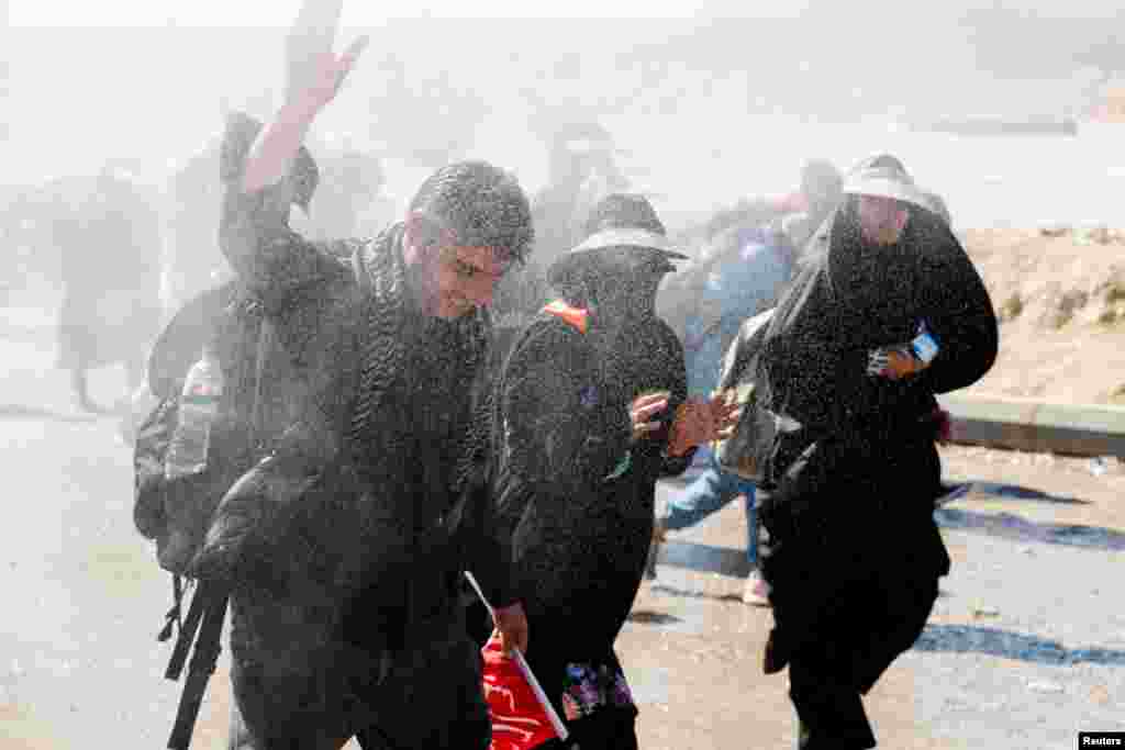 Iranian Shi&#39;ite pilgrims walk on a road after entering Iraq through the Zurbatia border crossing between Iran and Iraq, as they head towards Iraq&#39;s holy city of Kerbala to attend the holy Shi&#39;ite ritual of Arbaeen, in Zurbatia.