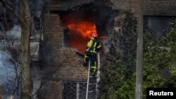 Firefighters work to put out a fire in a residential building hit by a Russian missile strike in Kyiv, Ukraine, Nov. 15, 2022.