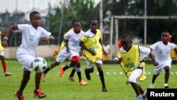 Anak-anak mengikuti program FIFA Football for Schools, yang terdiri dari pelatihan pendidik olahraga untuk memberikan pelatihan berkualitas kepada anak muda dan anak sekolah di Abidjan, Pantai Gading 9 November 2022. (REUTERS/Luc Gnago)