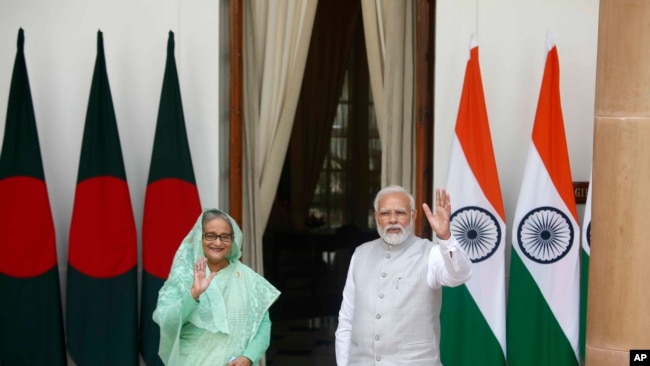 Indian Prime Minister Narendra Modi, right, and his Bangladeshi counterpart Sheikh Hasina wave to the waiting media before their delegation level talks in New Delhi, India, Tuesday, Sept. 6, 2022. 