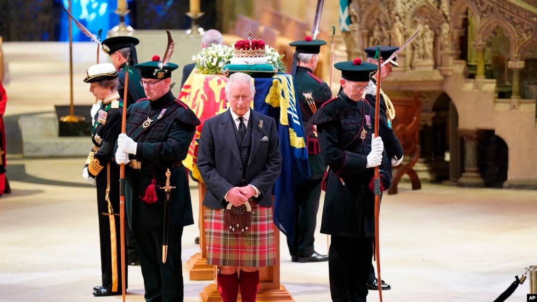 Britain's King Charles III, center, and other members of the royal family hold a vigil at the coffin of Queen Elizabeth II at St. Giles' Cathedral, Edinburgh, Scotland, Sept. 12, 2022, as members of the public walk past.