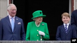 Pangeran Charles (kiri) menemani sang ibunda Ratu Elizabeth II dalam perayaan takhta sang ratu platinum jubilee dari balkon Istana Buckingham di London, pada 5 Juni 2022. (Foto: AP/Frank Augstein)