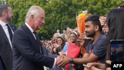 新继位的英王查尔斯三世在抵达白金汉时与等待他的民众握手。(2022年9月9日)