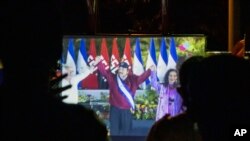 Los vecinos ven la toma de posesión del presidente Daniel Ortega, en una pantalla gigante en un parque en el barrio Julio Buitrago de Managua, Nicaragua, el 10 de enero de 2022.