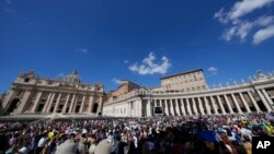 People gather as Pope Francis recites the Angelus noon prayer from the window of his studio overlooking St.Peter's Square, at the Vatican, Sept. 11, 2022. 