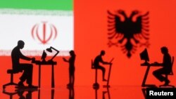Figurines with computers are seen in front of Iranian and Albanian flags in this photo illustration created Sept. 10, 2022. 