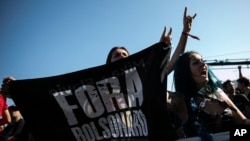 A music fan holds a flag with the Portuguese phrase "Out Bolsonaro" during the Rock in Rio music festival in Rio de Janeiro, Brazil, Sept. 2, 2022.
