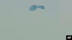 Esta imagen suministrada por Blue Origin muestra una cápsula espacial después de un lanzamiento fallido, cayendo en paracaídas sobre el desierto de Texas, el 12 de septiembre de 2022.