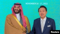 Putra Mahkota Arab Saudi, Mohammed bin Salman berjabat tangan dengan Presiden Korea Selatan Yoon Suk-yeol saat mereka berfoto, di Seoul, Korea Selatan, 17 November 2022. (Bandar Algaloud/Courtesy of Saudi Royal Court/Handout via REUTERS)