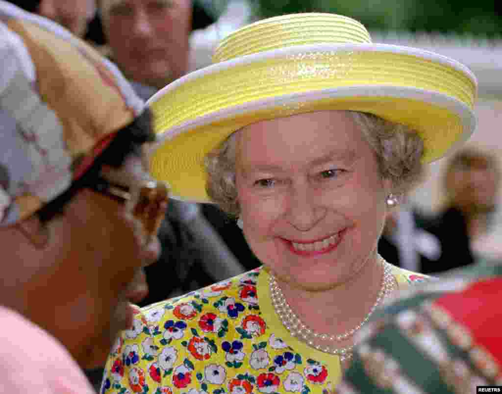 Britain&#39;s Queen Elizabeth II chats with an auid in the Natal Society for the Blind in Umbilo near Durban, March 25, 1995. Queen Elizabeth is on the last day of a six day visit to South Africa