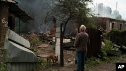 Oleksander Zaitsev, 67, stands in front of the house where his friend was found dead after a Russian attack in Pokrovsk region, Ukraine, Sunday, Sept. 11, 2022. (AP Photo/Leo Correa)