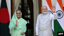 ভারতের প্রধানমন্ত্রী নরেন্দ্র মোদি এবং তার বাংলাদেশের প্রধানমন্ত্রী শেখ হাসিনা নয়াদিল্লির হায়দ্রাবাদ হাউসে তাদের বৈঠকের আগে ছবির তোলার জন্য দাঁড়িয়েছেন।৬ সেপ্টেম্বর,২০২২। (ছবি মানি শর্মা / এএফপি)