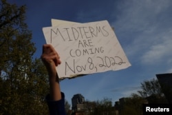 A demonstrator holds a sign reading "Midterms are Coming Nov 8, 2022" during a protest in support of abortion rights in front of the Massachusetts State House in Boston, May 3, 2022.