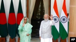 ভারতের প্রধানমন্ত্রী নরেন্দ্র মোদি এবং বাংলাদেশের প্রধানমন্ত্রী শেখ হাসিনা ভারতের নয়াদিল্লিতে তাদের প্রতিনিধি পর্যায়ের আলোচনার আগে অপেক্ষমাণ সংবাদদাতাদের উদ্দেশ্যে হাত নাড়ছেন। ৬ সেপ্টেম্বর, ২০২২। (ছবি-এপি)