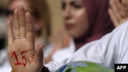 An activist with paint on her hand reading "1.5 degrees", alluding to demands to limit global temperature rise to 1.5 degrees Celsius compared to pre-industrial levels, during a demonstration at the COP27 climate conference in Egypt on November 16, 2022.