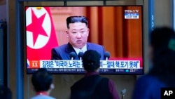 People watch a TV screen showing a news program reporting with file footage of North Korean leader Kim Jong Un, at the Seoul Railway Station in Seoul, South Korea, Sept. 9, 2022.