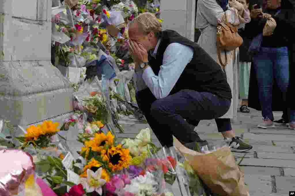 A mourner is overcome with emotion as he pays his respects at the gates of Buckingham Palace in London.