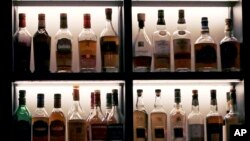 FILE - Scotch bottles are displayed at Wink & Nod in Boston, on Dec. 10, 2019. In Massachusetts, Democrats and Republicans could find an issue to agree on: letting bars have happy hours. (AP Photo/Charles Krupa, File)