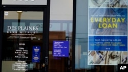 FILE - A loan sign is displayed at a Des Plaines Bank & Trust in Des Plaines, Illinois, July 11, 2021. A growing number of people in the U.S. are looking to friends and family, instead of financial institutions, as a means to borrow money.